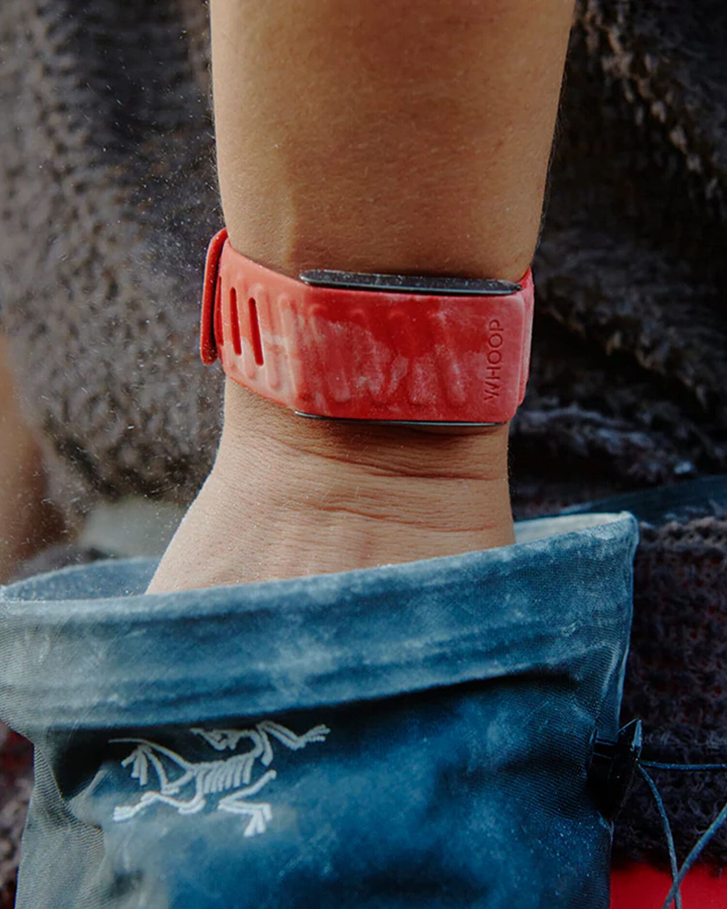 Athlete wearing a red WHOOP fitness and recovery tracker during outdoor activity designed for continuous biometric monitoring