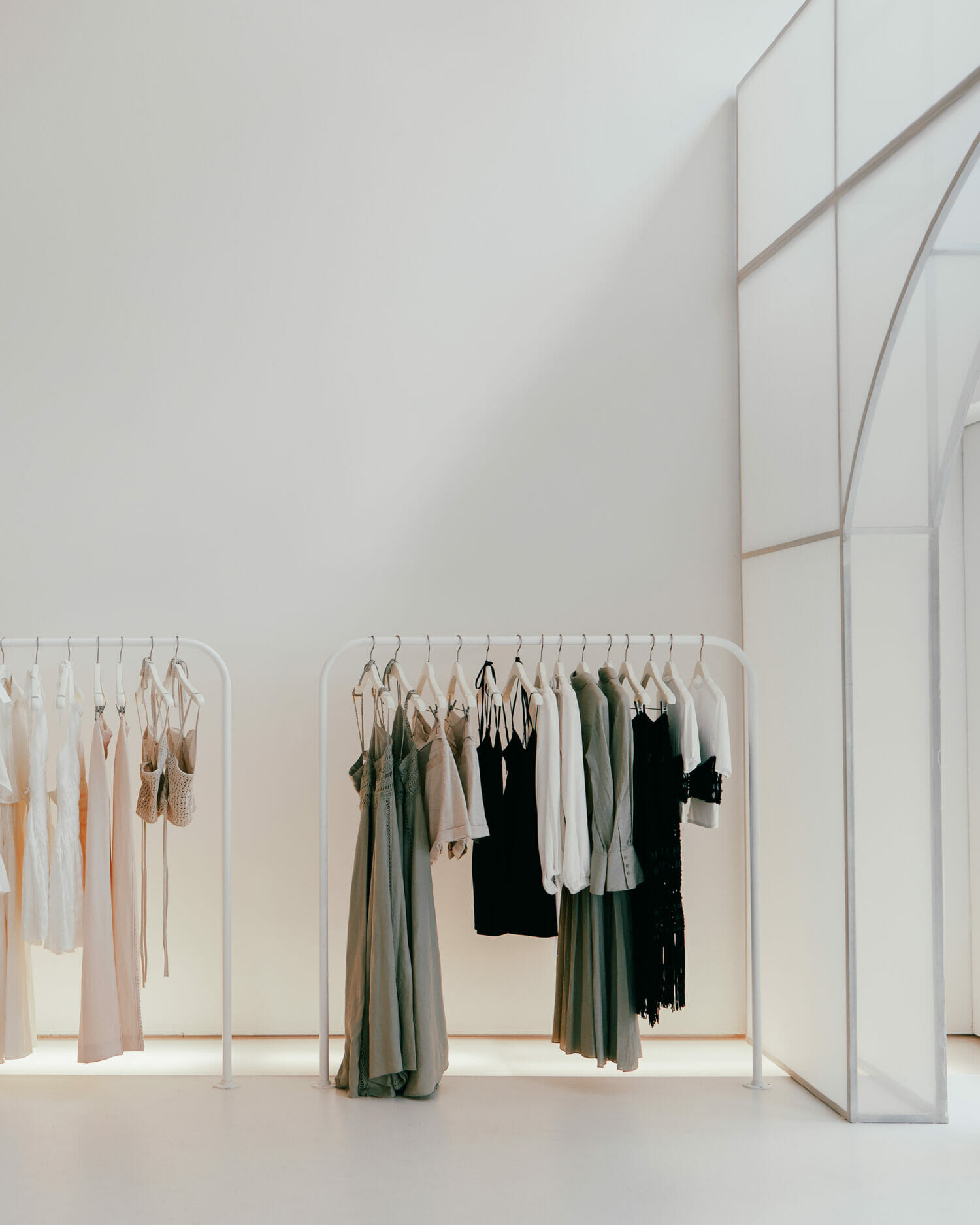 Simkhai clothing racks displaying dresses, tailoring, and contemporary garments inside a luxury boutique.
