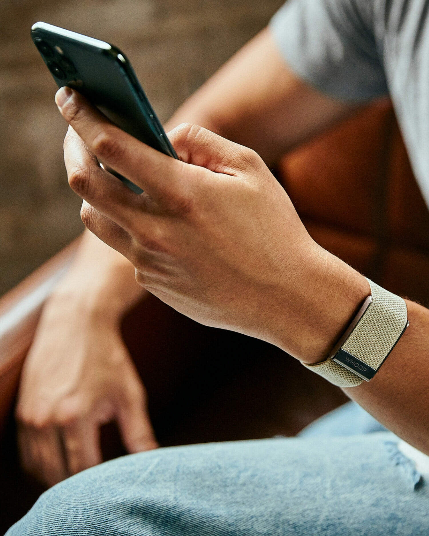 WHOOP's wearble fitness tracker shown on a person's wrist, showcasing product design work by Aruliden.