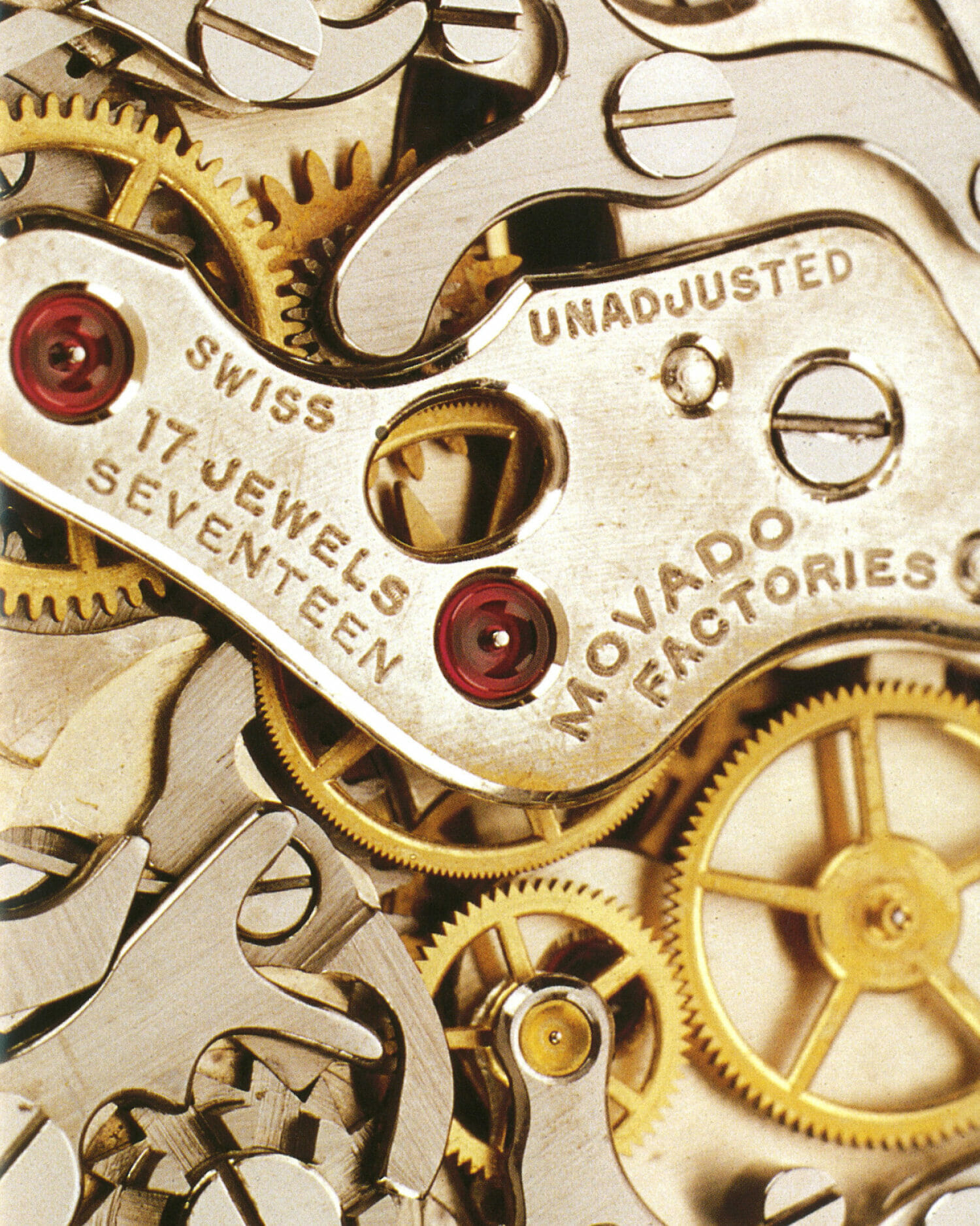 Movado watch movement showing intricate gears, ruby jewels, and engraved text reading “17 Jewels” and “Movado Factories.”