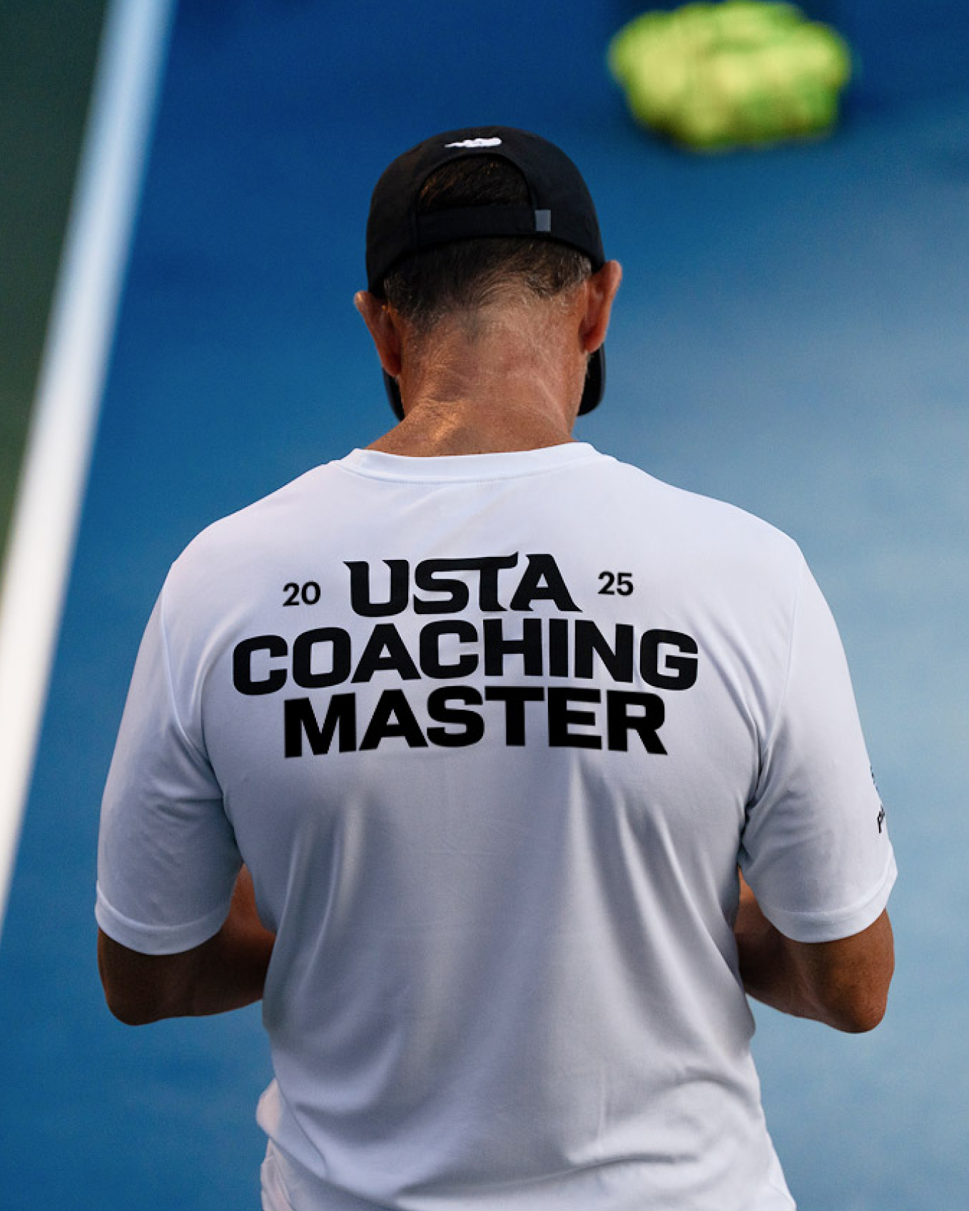 Man representing USTA coaching brand by wearing brand's t-shirt