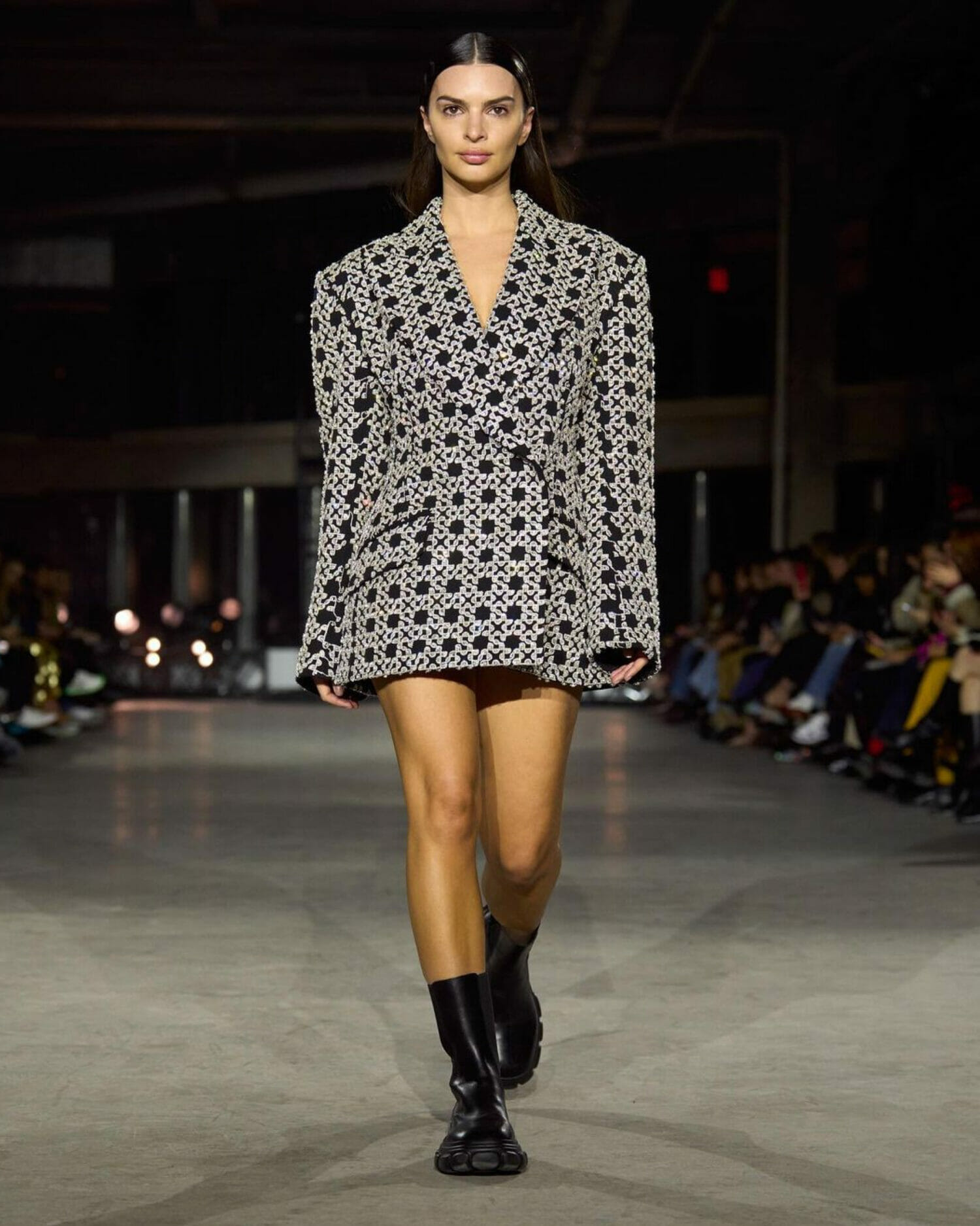 Model walking the runway in Simkhai blazer pattern paired with black ankle boots.