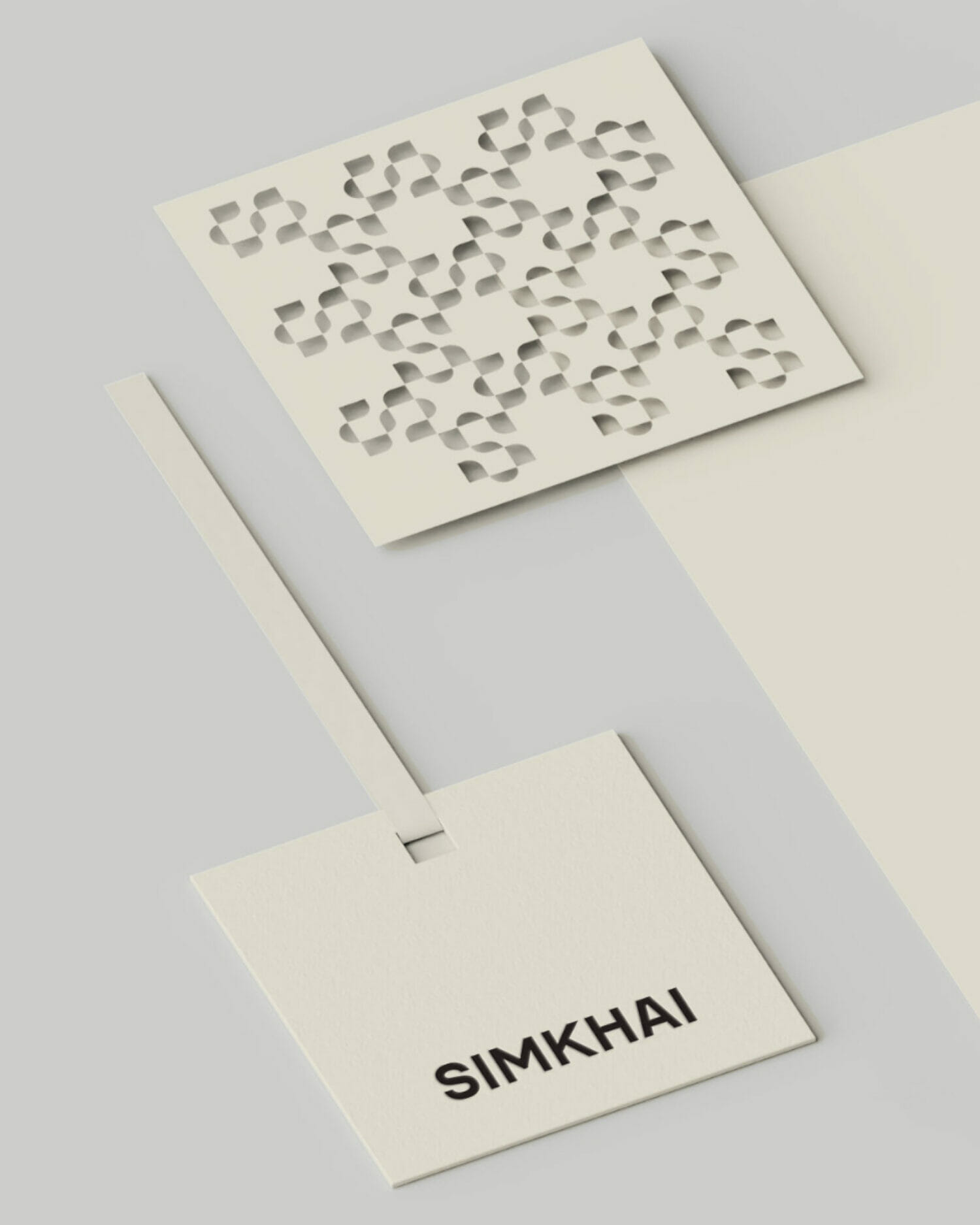 Simkhai brand tag and packaging design on cream colored stationery.
