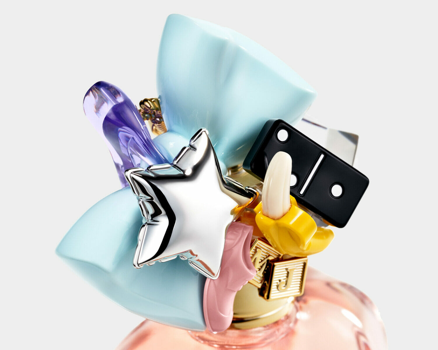 Perfect marc jacobs perfume bottle cap featuring oversized pastel bows, a silver star, banana charm, pink shoe, and black domino piece.