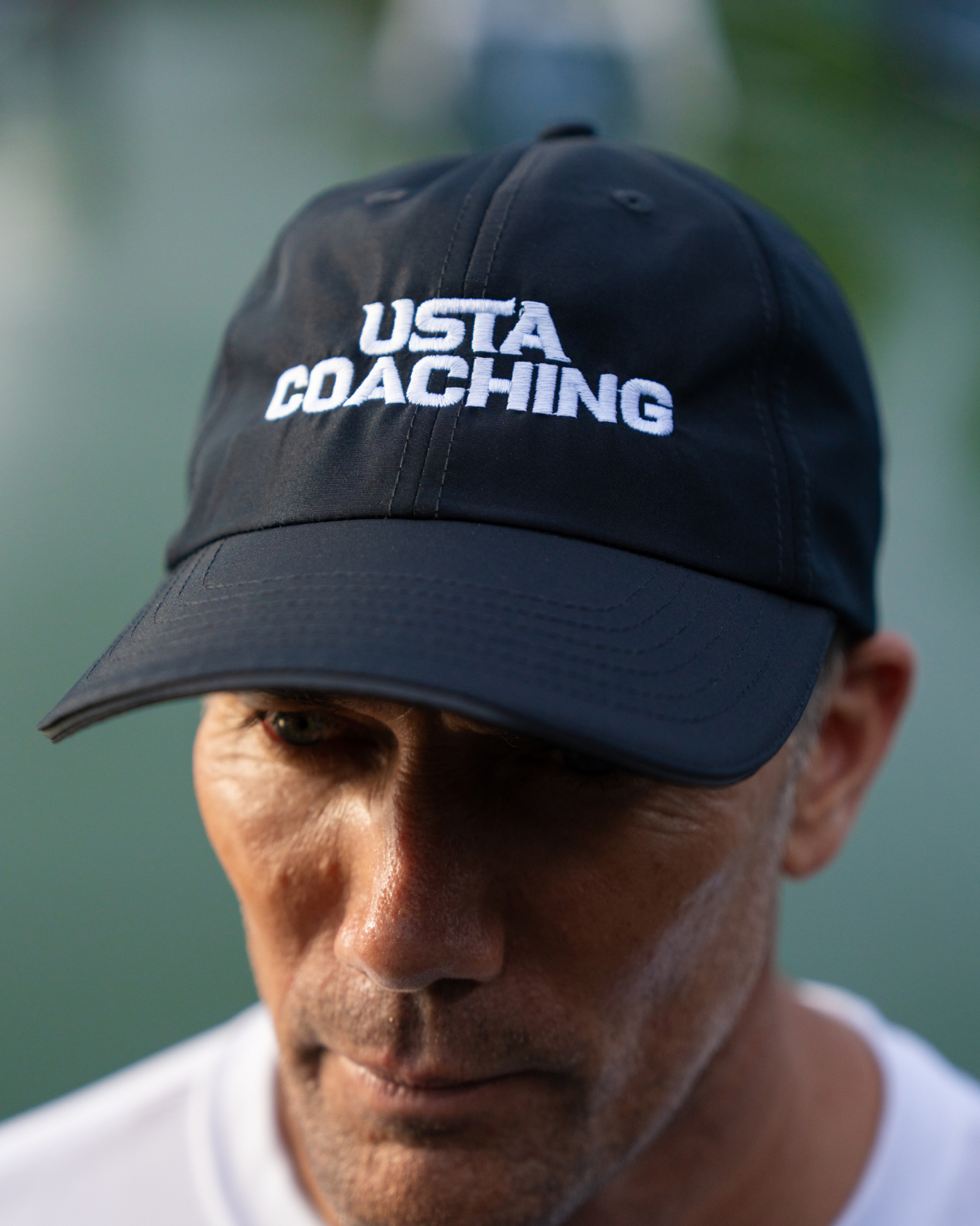Man representing USTA coaching brand by wearing a cap